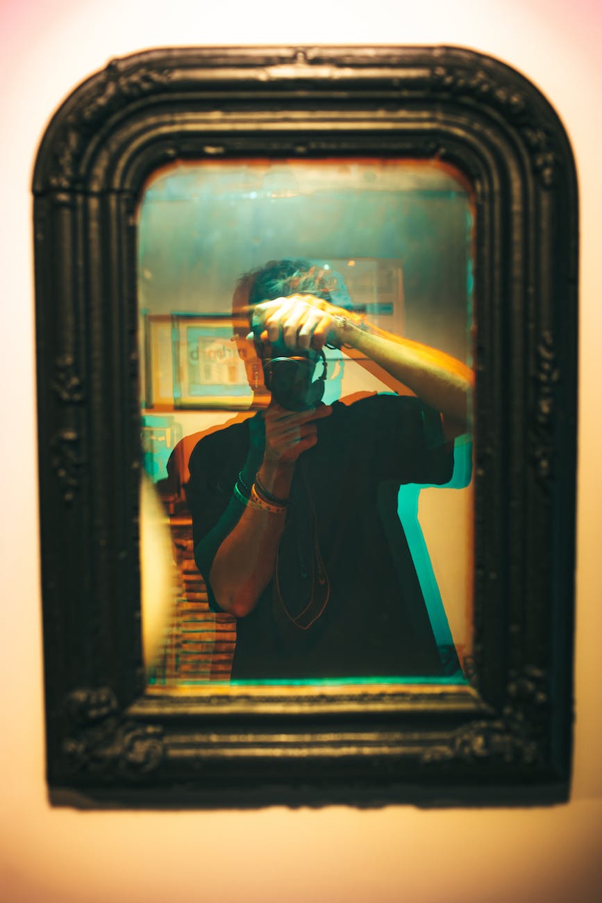 man in black shirt having a selfie on the mirror