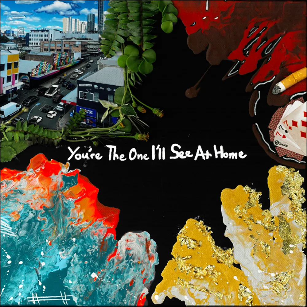 A vibrant mixed media artwork featuring a cityscape with buildings and traffic, surrounded by colorful abstract textures in red, blue, and gold. The text 'You're The One I'll See At Home' is prominently displayed in white.